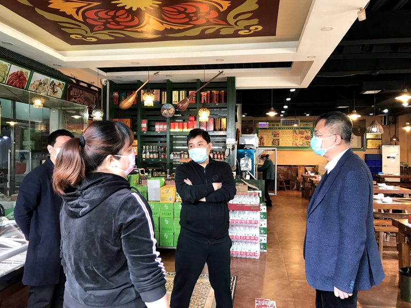 在百年味道面馆,柳波一行在保持距离排队测量体温,手部酒精消毒后